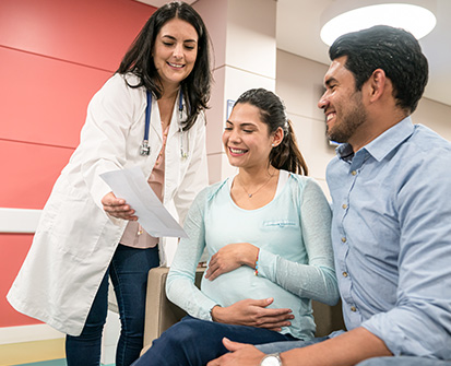 doctora mostrando resultados a mujer embarazada y a su pareja