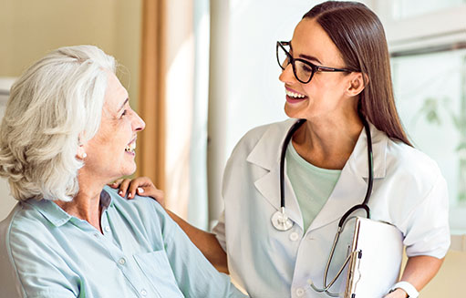 doctora sonrie junto a mujer de edad