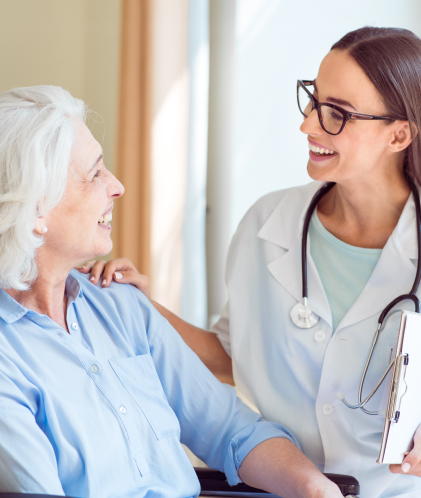 doctora sonrie junto a mujer de edad