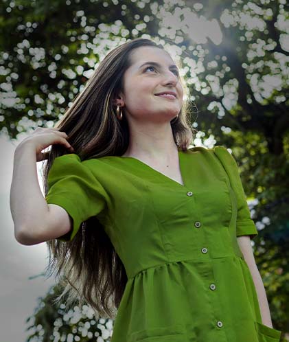 mujer jugando con su cabello bajo un arbol