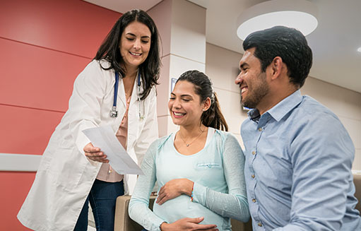 doctora mostrando resultados a mujer embarazada y a su pareja