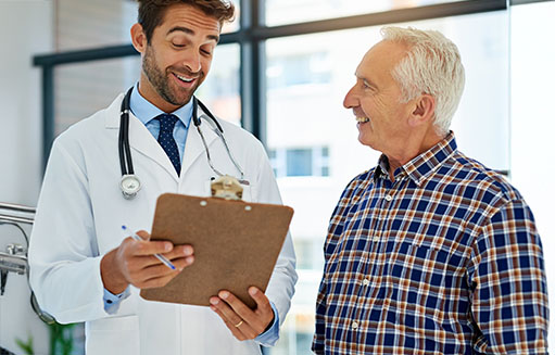 hombre mayor sonriendo junto a medico de colsubsidio