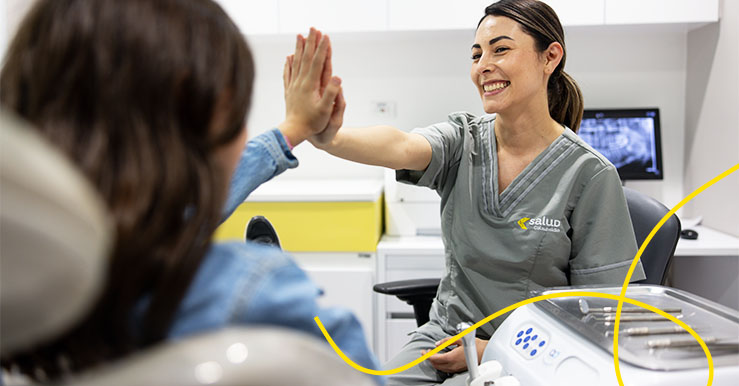odontologa chocanco la mano con paciente