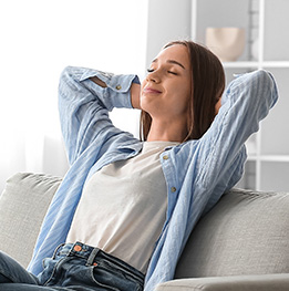 mujer relajada esta sentada en el sofa 